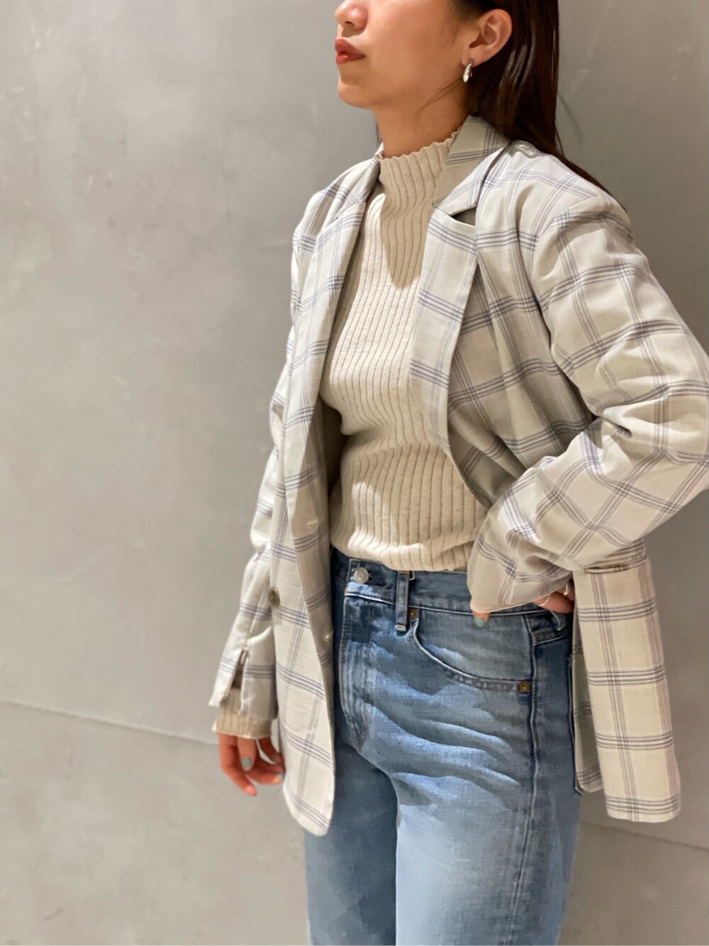 ブルー系のテーラードジャケット、ブルー系のデニムパンツ、ホワイト系のニット/セーターを着用したレディースの冬コーディネートの4枚目の写真