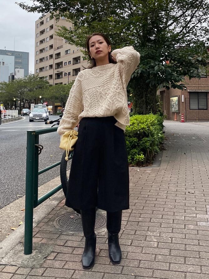 ブラック系のその他パンツ、ブラック系のブーツ、ホワイト系のニット/セーターを着用したレディースの秋コーディネートの3枚目の写真
