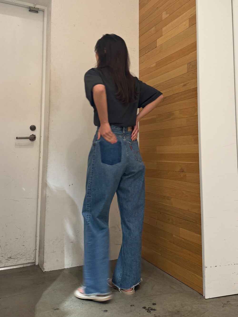 ブルー系のデニムパンツ、グレー系のTシャツ/カットソー、ブラック系のサンダルを着用したレディースの春コーディネートの4枚目の写真