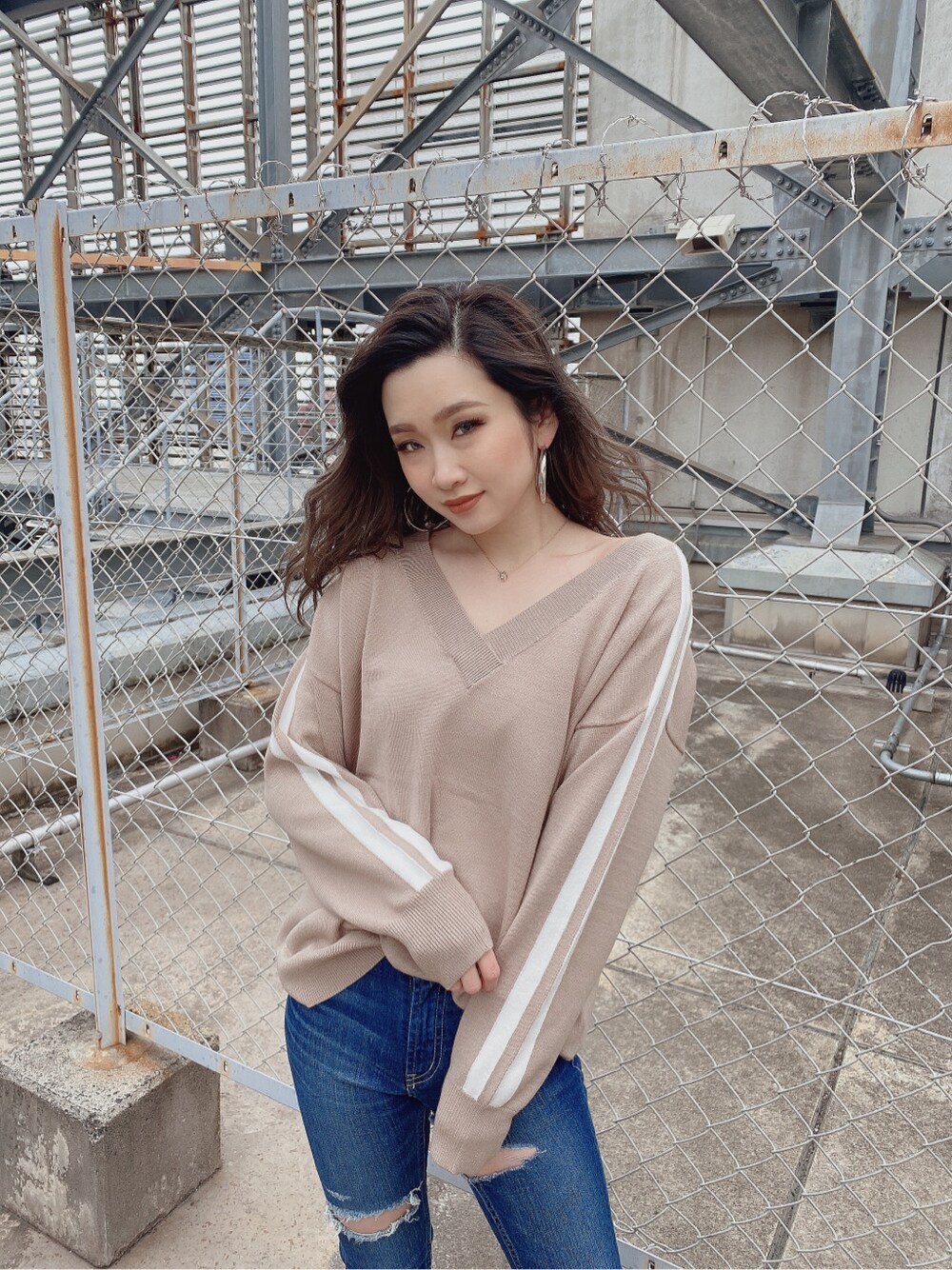 ブルー系のデニムパンツ、ベージュ系のニット/セーターを着用したレディースの冬コーディネートの2枚目の写真