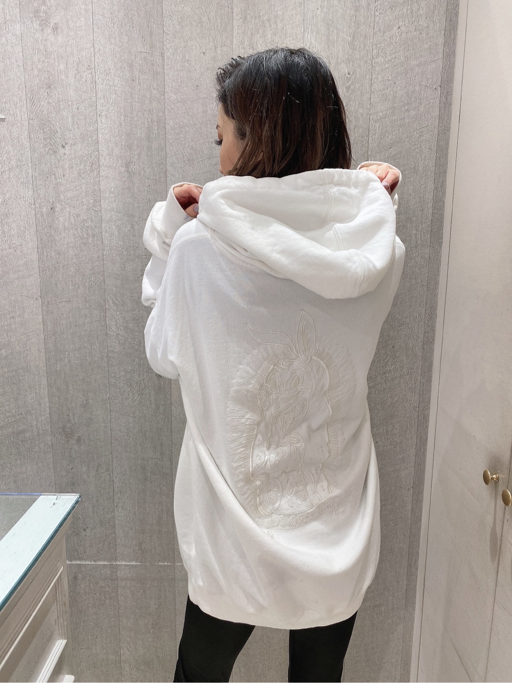 ホワイト系のパーカー、ブラック系のレギンス/スパッツを着用したレディースの冬コーディネートの4枚目の写真