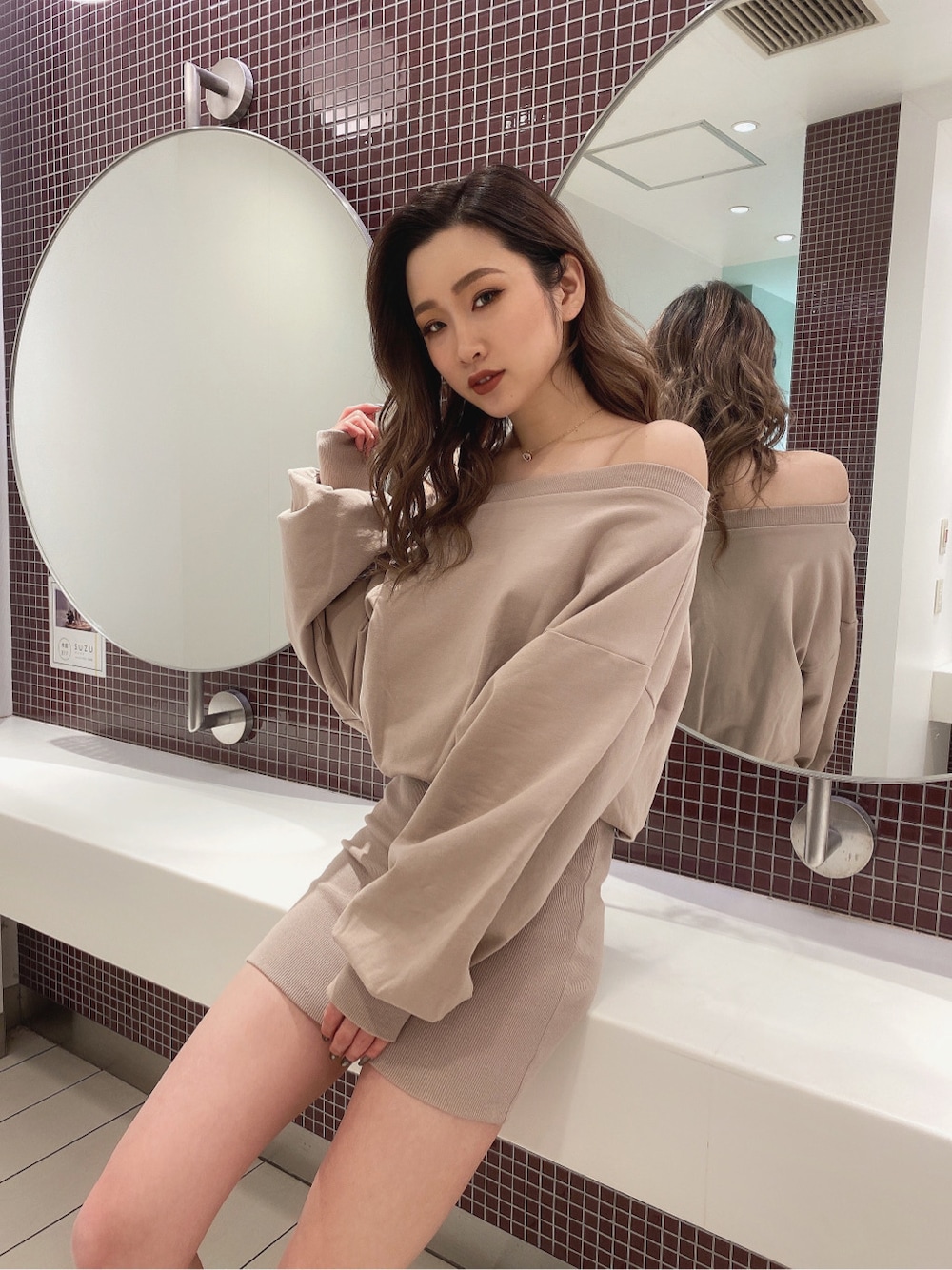 ベージュ系のワンピースを着用したレディースの冬コーディネートの2枚目の写真