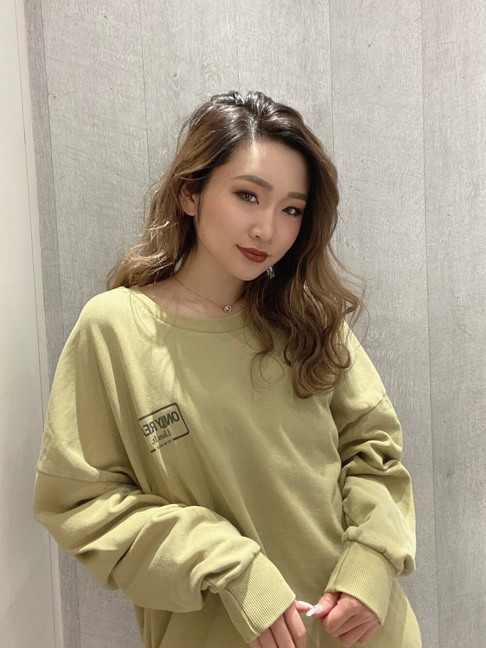 イエロー系のスウェットを着用したレディースの冬コーディネートの2枚目の写真