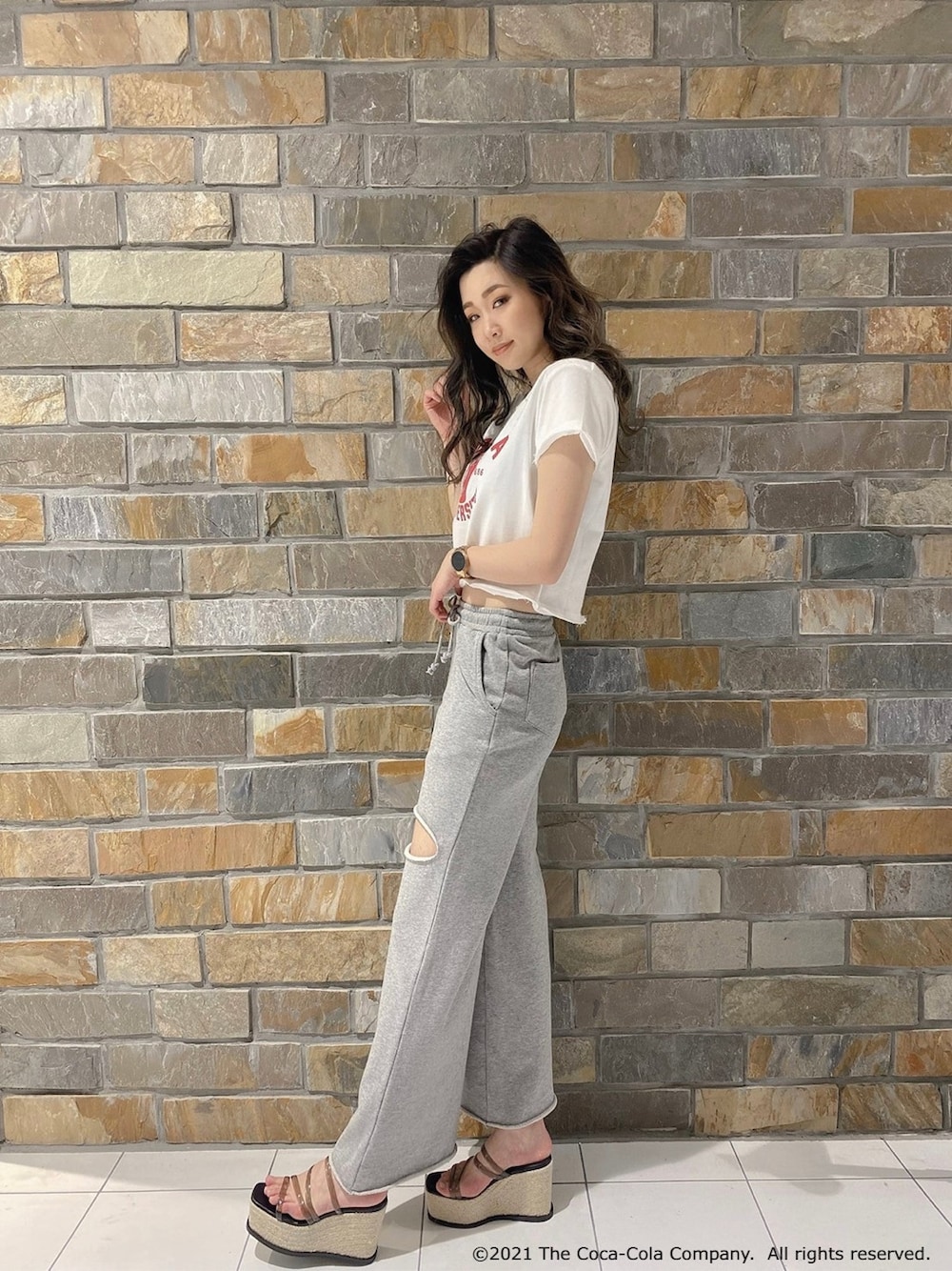 グレー系のスウェットパンツ、ホワイト系のTシャツ/カットソー、ブラック系のサンダルを着用したレディースの春コーディネートの2枚目の写真