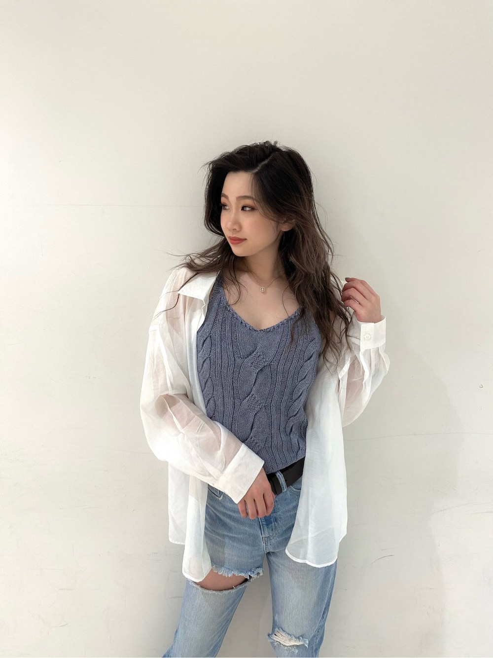 ブルー系のデニムパンツ、ベージュ系のサンダル、ブルー系のキャミソールを着用したレディースの春コーディネートの2枚目の写真