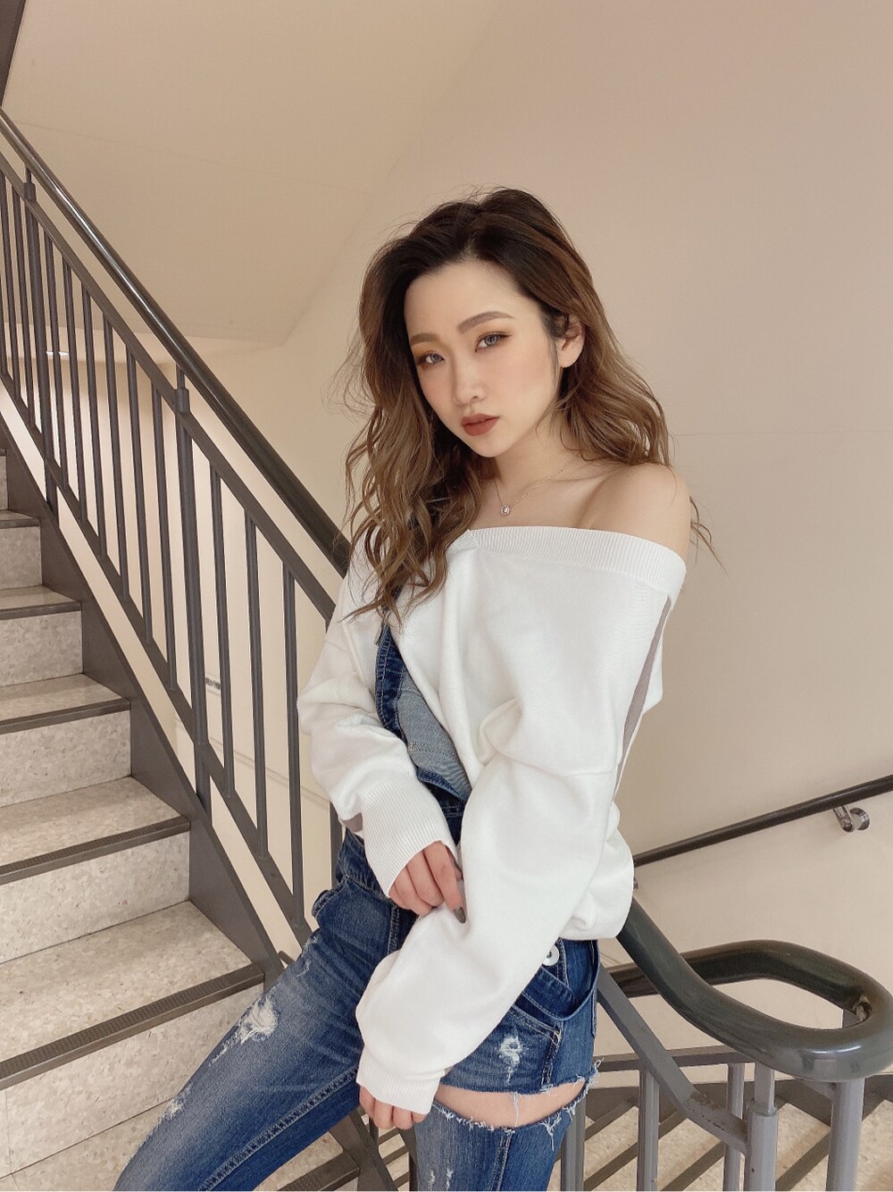 ブルー系のサロペット/オーバーオール、ホワイト系のニット/セーターを着用したレディースの冬コーディネートの3枚目の写真