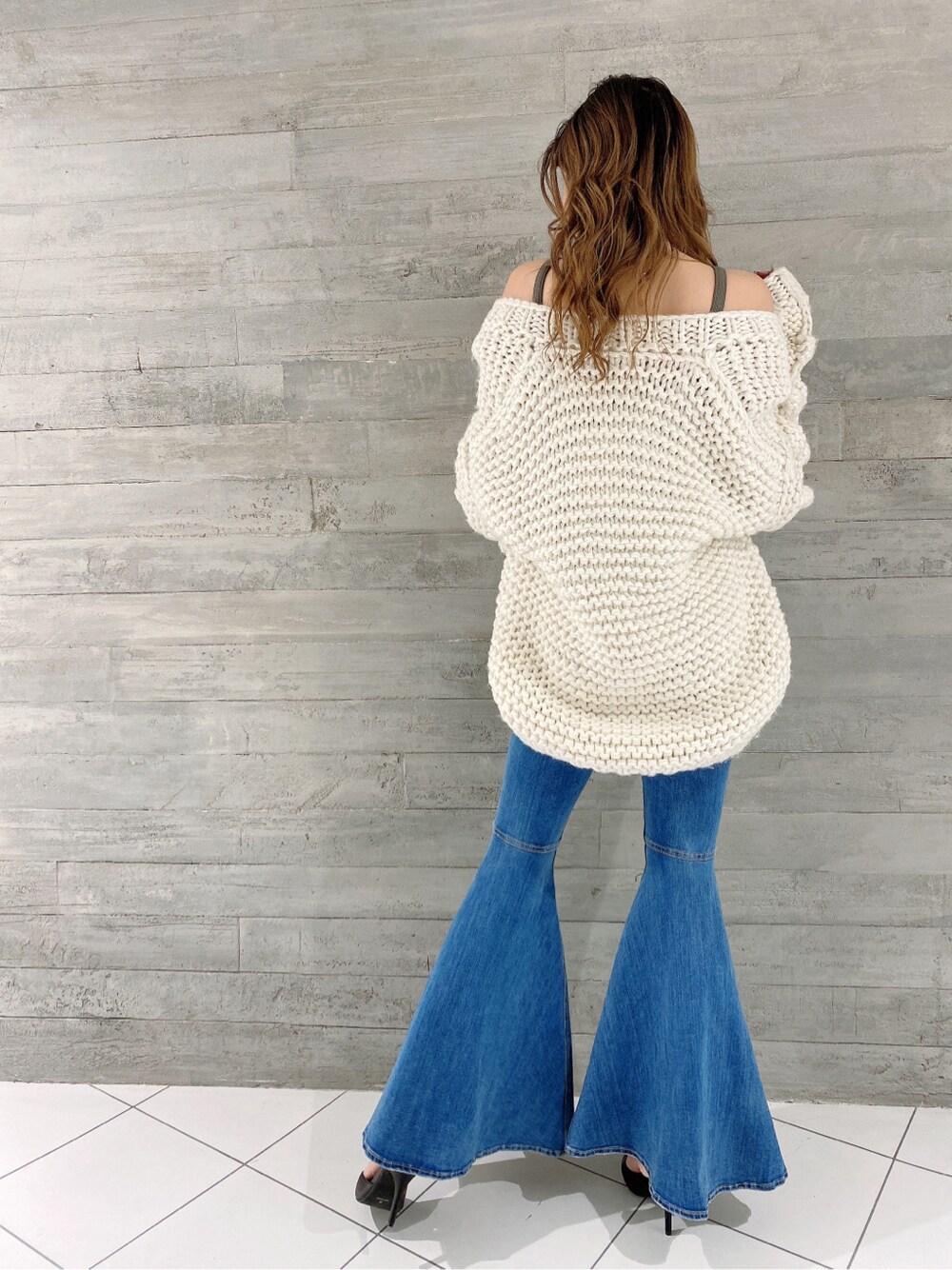 ブラック系のパンプス、ブルー系のデニムパンツ、ベージュ系のキャミソールを着用したレディースの冬コーディネートの4枚目の写真