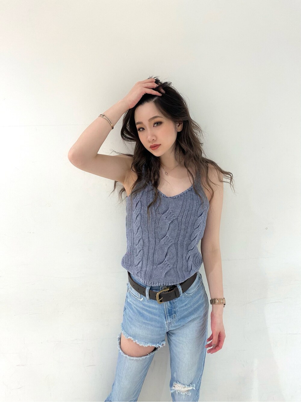 ブルー系のデニムパンツ、ベージュ系のサンダル、ブルー系のキャミソールを着用したレディースの春コーディネートの3枚目の写真