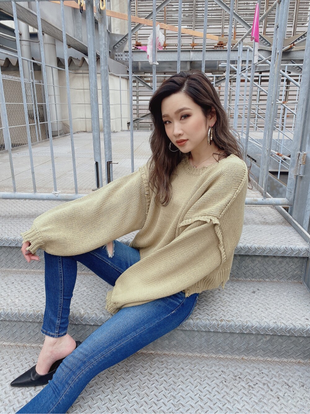 ブルー系のデニムパンツ、グリーン系のニット/セーターを着用したレディースの冬コーディネートの2枚目の写真