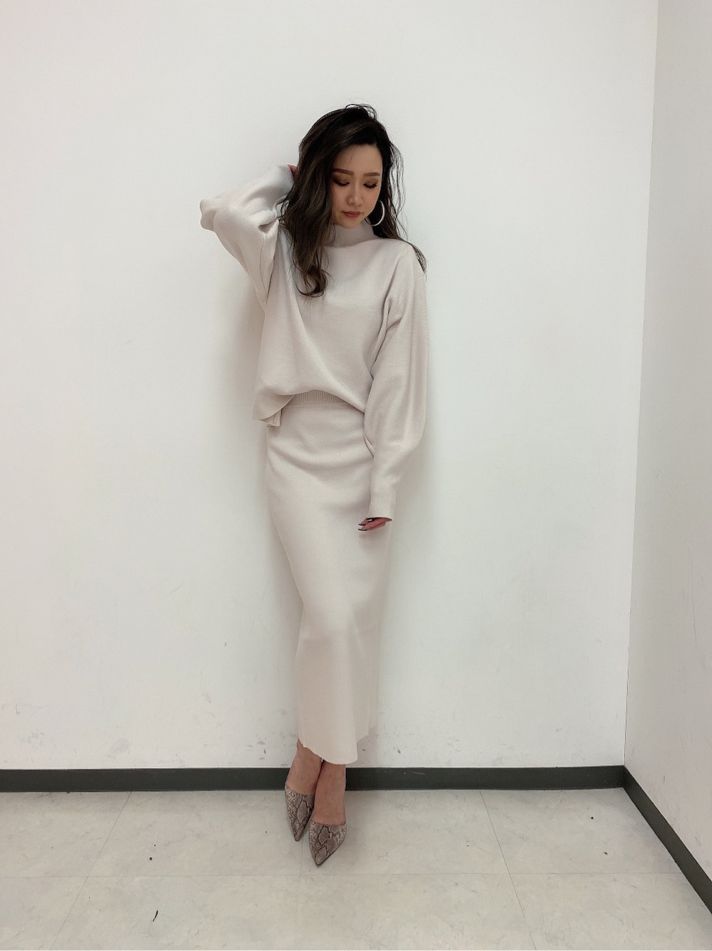 ホワイト系のスカート、ホワイト系のニット/セーターを着用したレディースの冬コーディネートの2枚目の写真