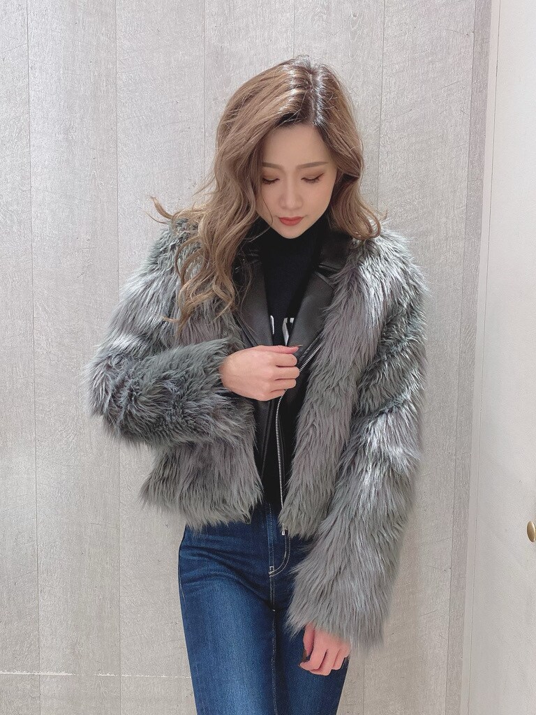 グレー系のライダースジャケット、ブルー系のデニムパンツ、ブラック系のニット/セーターを着用したレディースの秋コーディネートの2枚目の写真