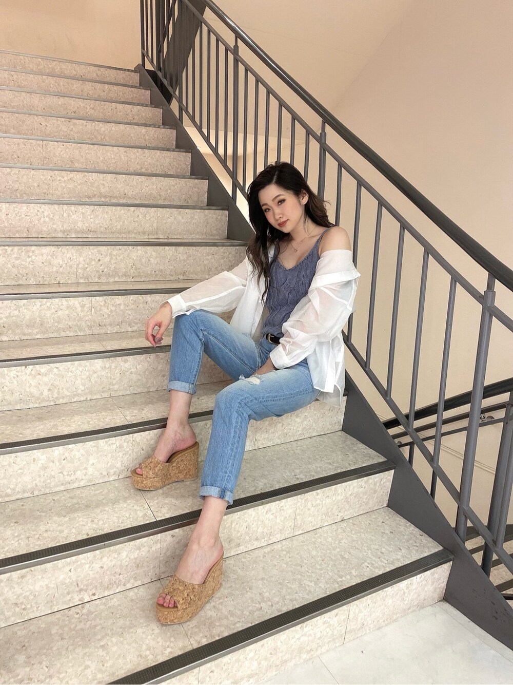 ブルー系のデニムパンツ、ベージュ系のサンダル、ブルー系のキャミソールを着用したレディースの春コーディネートの4枚目の写真