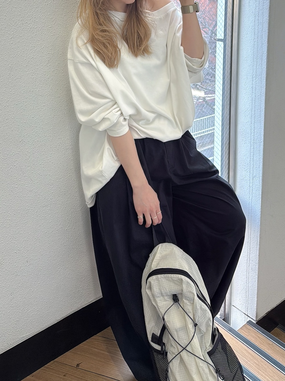 ホワイト系のTシャツ/カットソー、ブラック系のその他パンツ、ホワイト系のバックパック/リュックを着用したレディースの春コーディネートの2枚目の写真