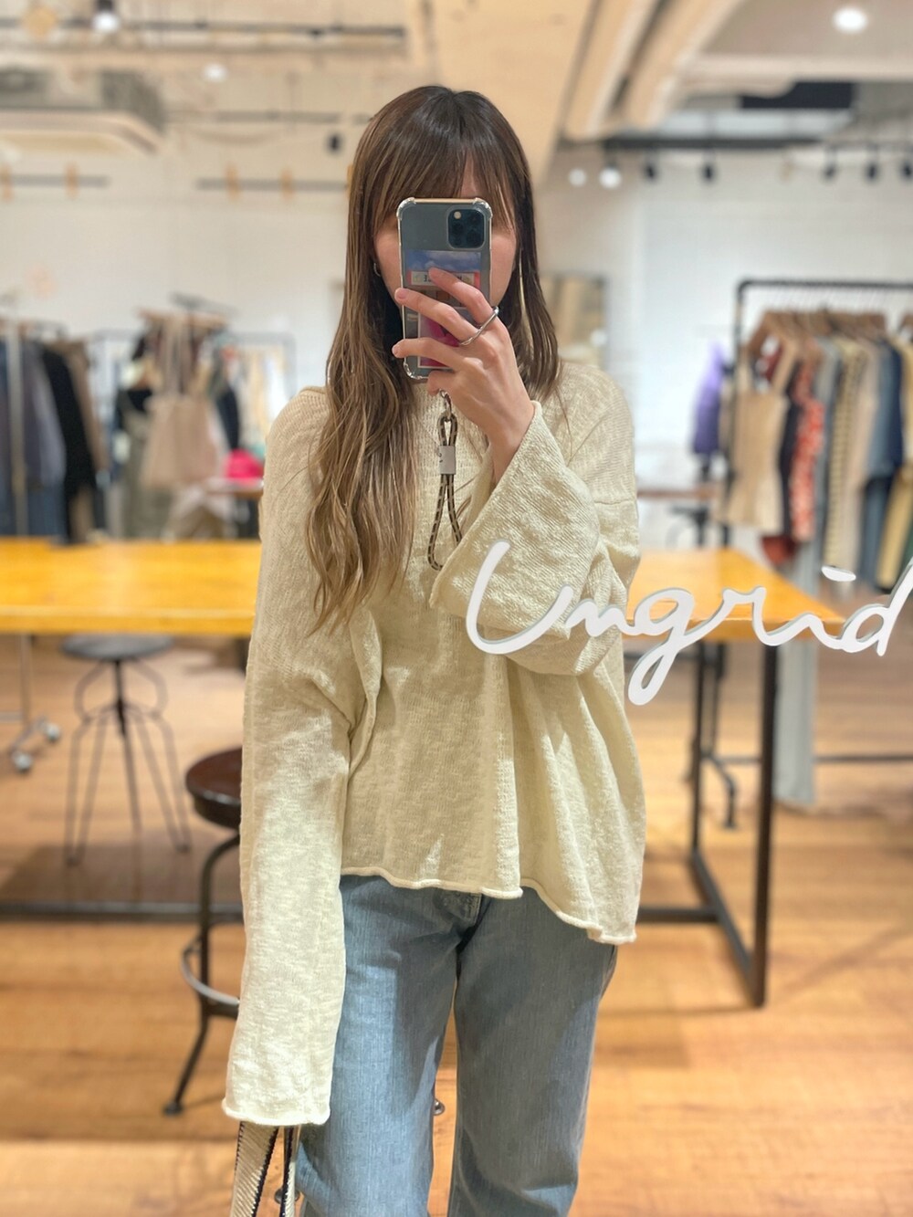 ホワイト系のニット/セーター、ブルー系のデニムパンツ、ホワイト系のハンドバッグを着用したレディースの冬コーディネートの4枚目の写真