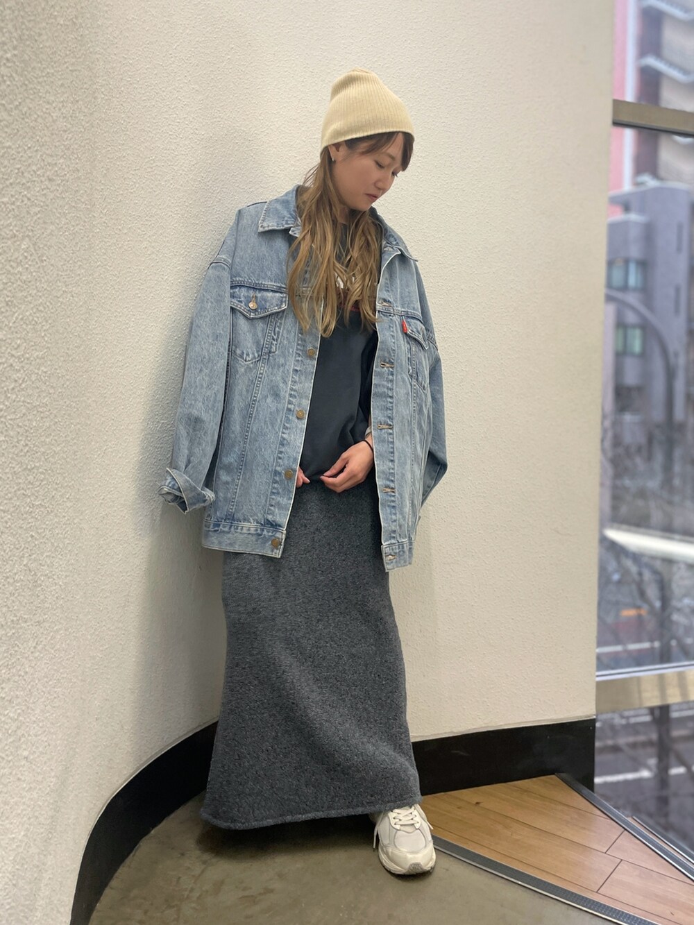 ブルー系のデニムジャケット、グレー系のスカート、グレー系のスウェットを着用したレディースの冬コーディネートの2枚目の写真