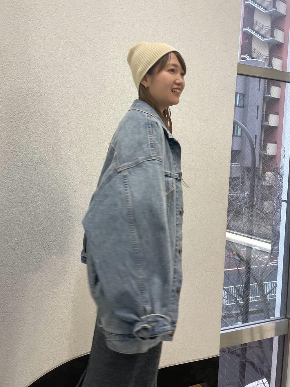 ブルー系のデニムジャケット、グレー系のスカート、グレー系のスウェットを着用したレディースの冬コーディネートの3枚目の写真