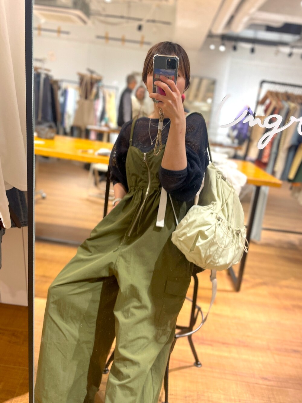 グレー系のTシャツ/カットソー、ベージュ系のバックパック/リュック、グリーン系のサロペット/オーバーオールを着用したレディースの冬コーディネートの3枚目の写真