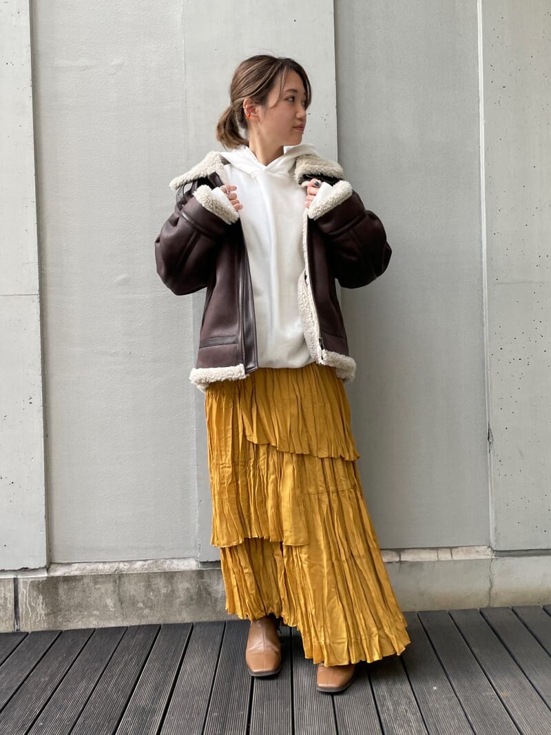ブラウン系のブルゾン、イエロー系のスカート、ホワイト系のパーカーを着用したレディースの夏コーディネートの3枚目の写真