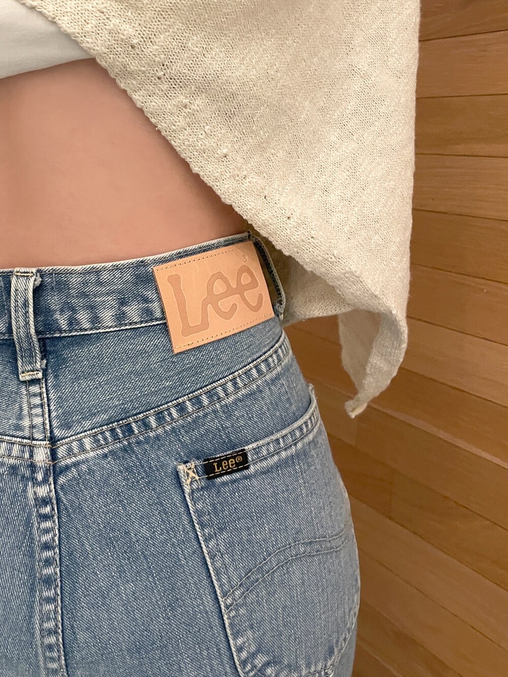 ホワイト系のニット/セーター、ブルー系のデニムパンツ、ホワイト系のハンドバッグを着用したレディースの冬コーディネートの3枚目の写真