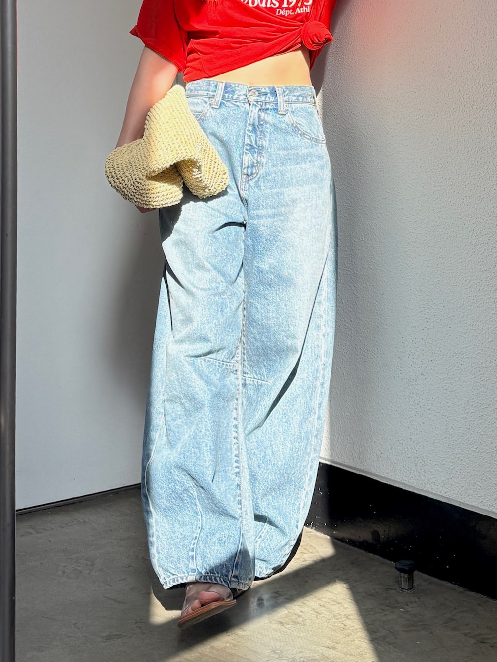 ブルー系のデニムパンツ、レッド系のTシャツ/カットソー、その他のサンダルを着用したレディースの春コーディネートの4枚目の写真