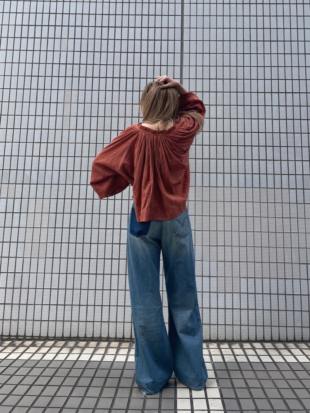 ブルー系のデニムパンツ、オレンジ系のシャツ/ブラウスを着用したレディースの秋コーディネートの4枚目の写真