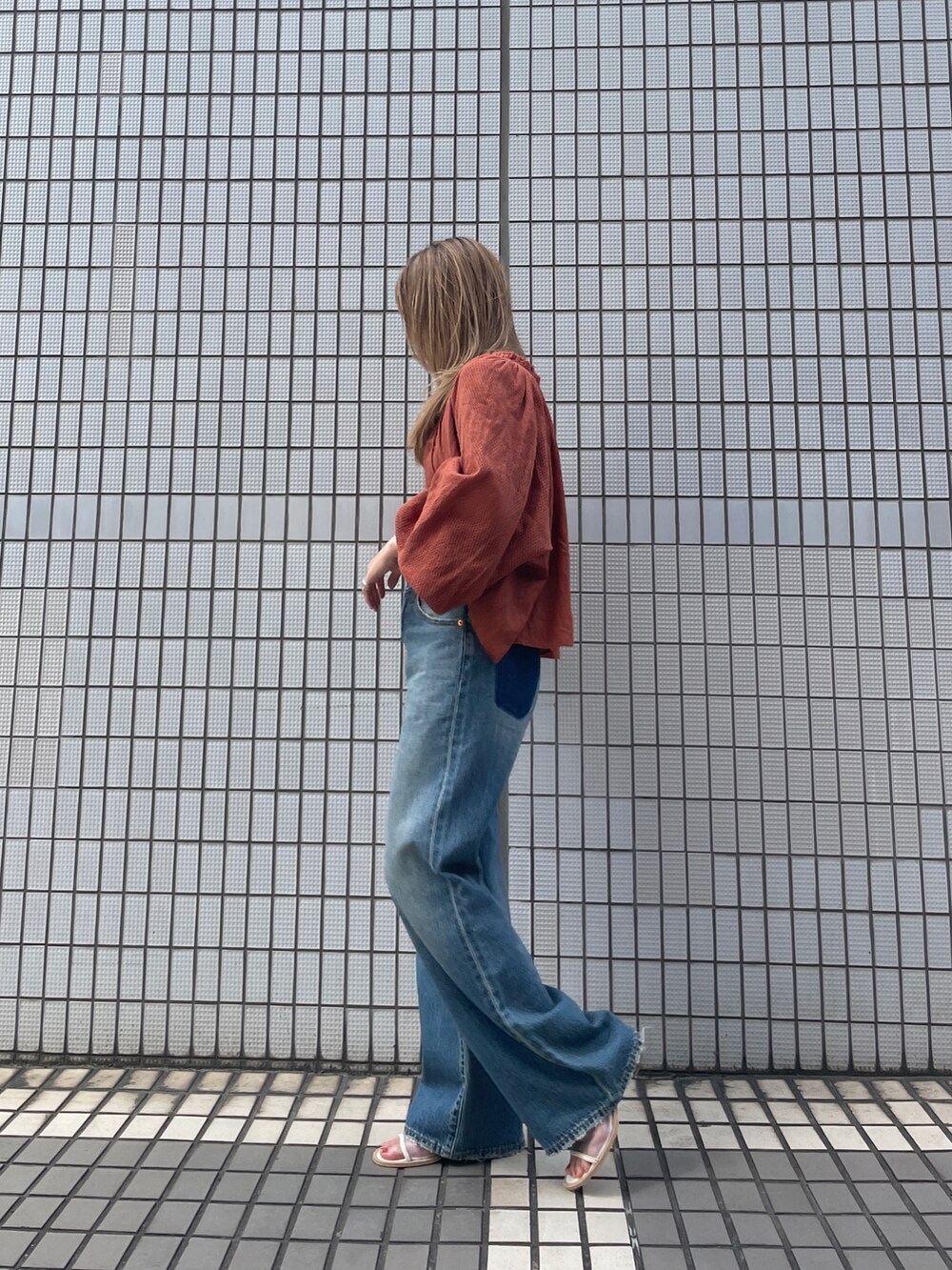 ブルー系のデニムパンツ、オレンジ系のシャツ/ブラウスを着用したレディースの秋コーディネートの3枚目の写真