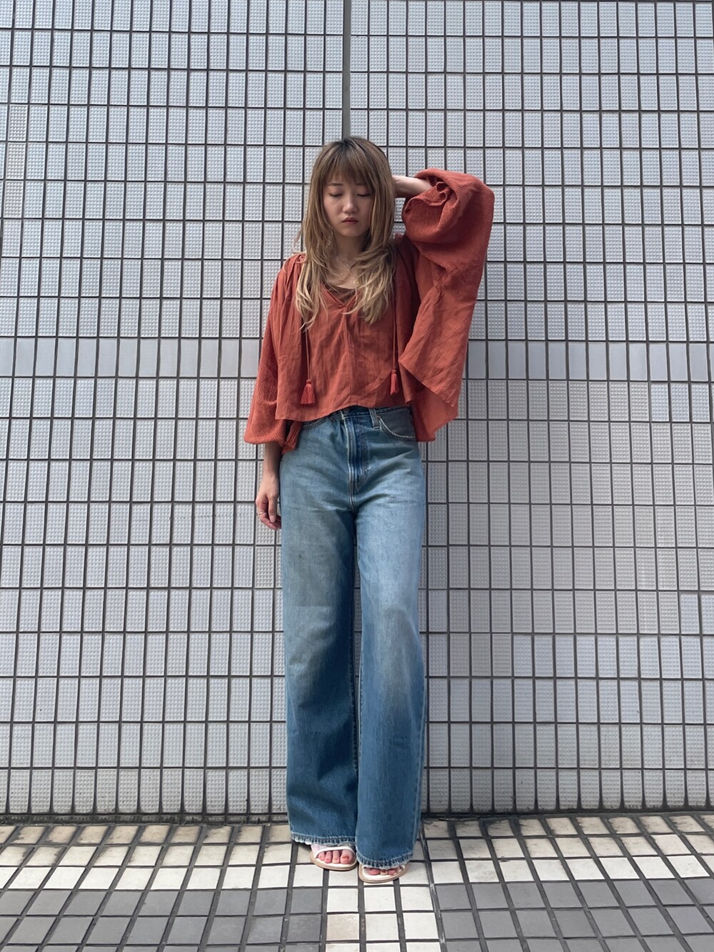 ブルー系のデニムパンツ、オレンジ系のシャツ/ブラウスを着用したレディースの秋コーディネートの2枚目の写真