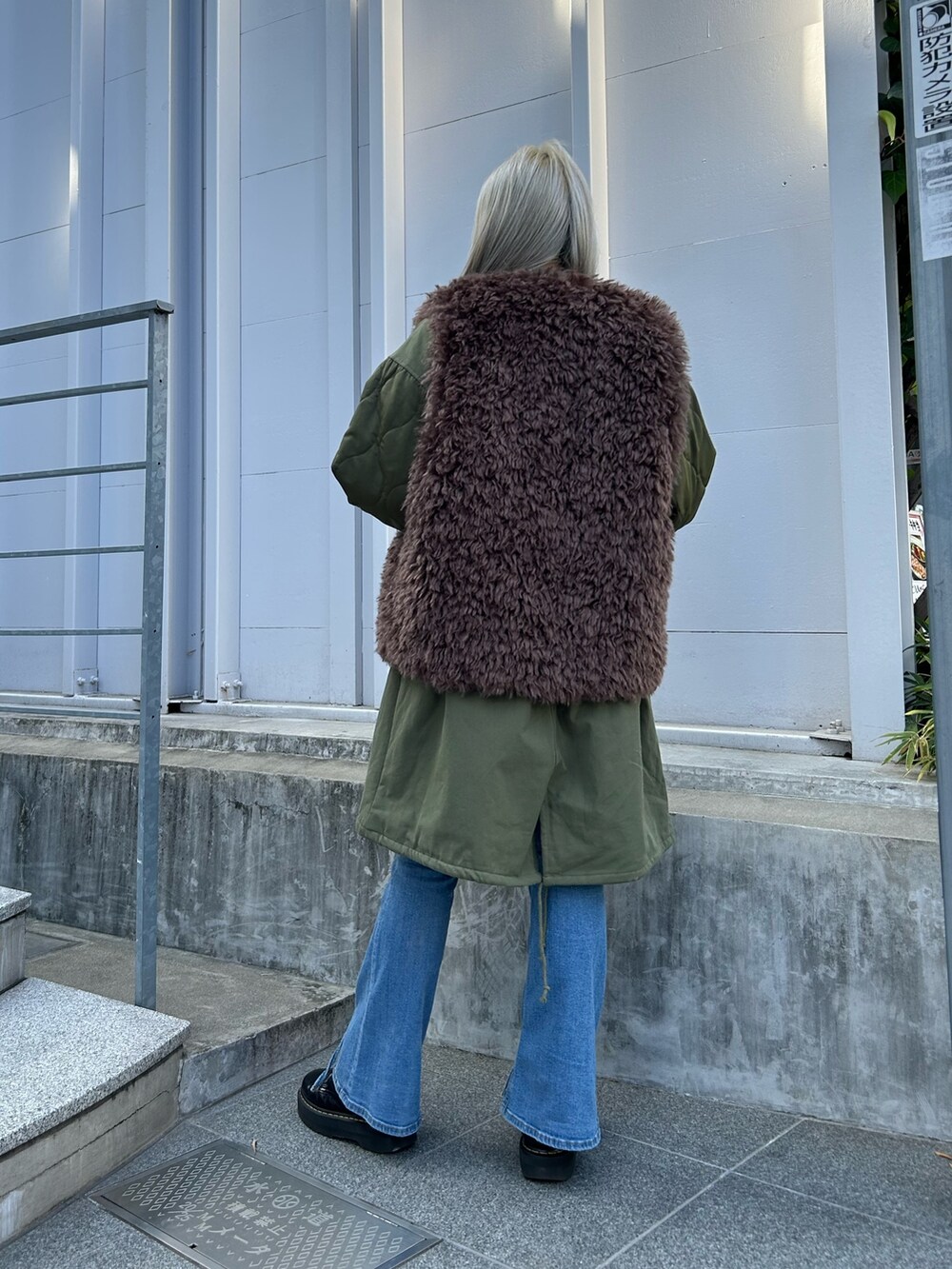 グリーン系のモッズコート、レッド系のニット/セーター、ホワイト系のTシャツ/カットソーを着用したレディースの秋コーディネートの3枚目の写真