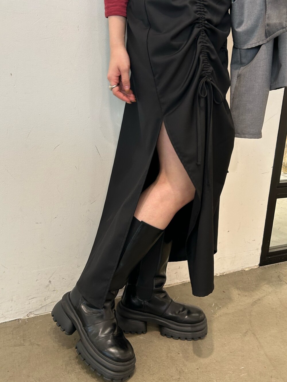 ブラック系のブーツ、ブラック系のワンピース、ブルー系のTシャツ/カットソーを着用したレディースの春コーディネートの7枚目の写真