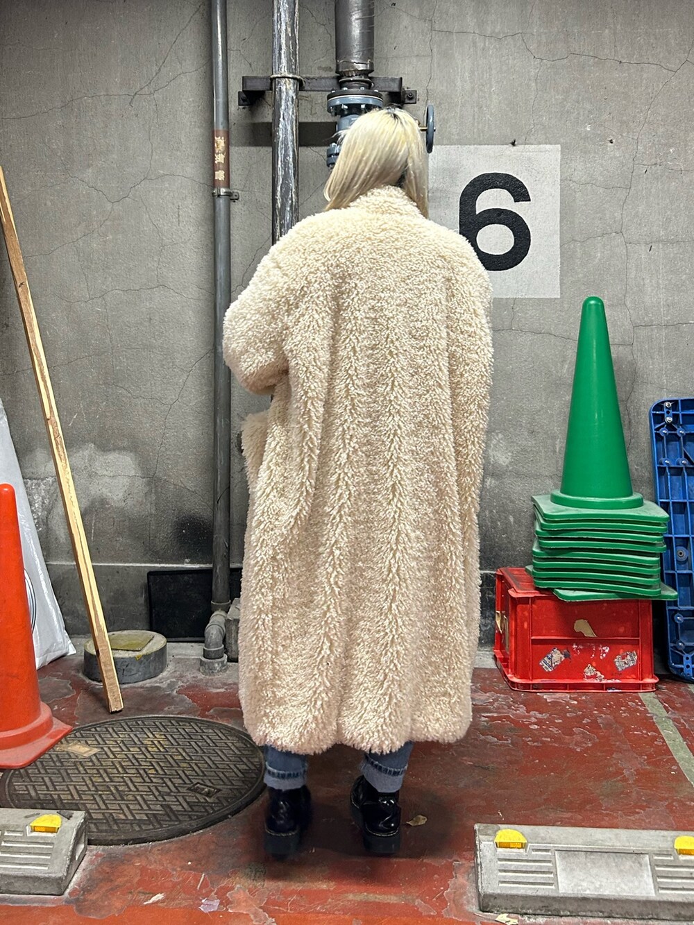 レッド系のニット/セーター、ブルー系のデニムパンツ、ホワイト系のその他アウターを着用したレディースの冬コーディネートの2枚目の写真