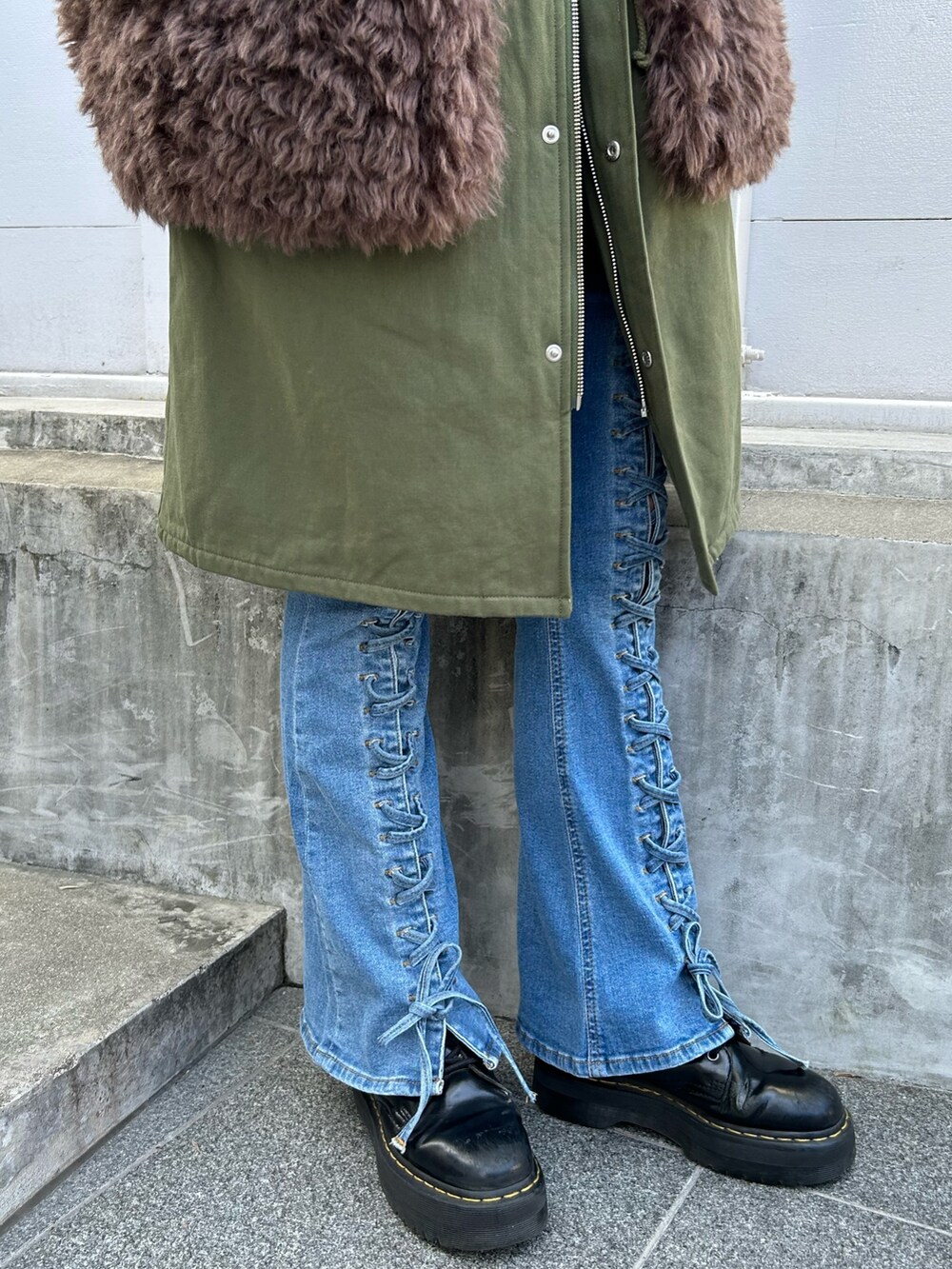 グリーン系のモッズコート、レッド系のニット/セーター、ホワイト系のTシャツ/カットソーを着用したレディースの秋コーディネートの8枚目の写真