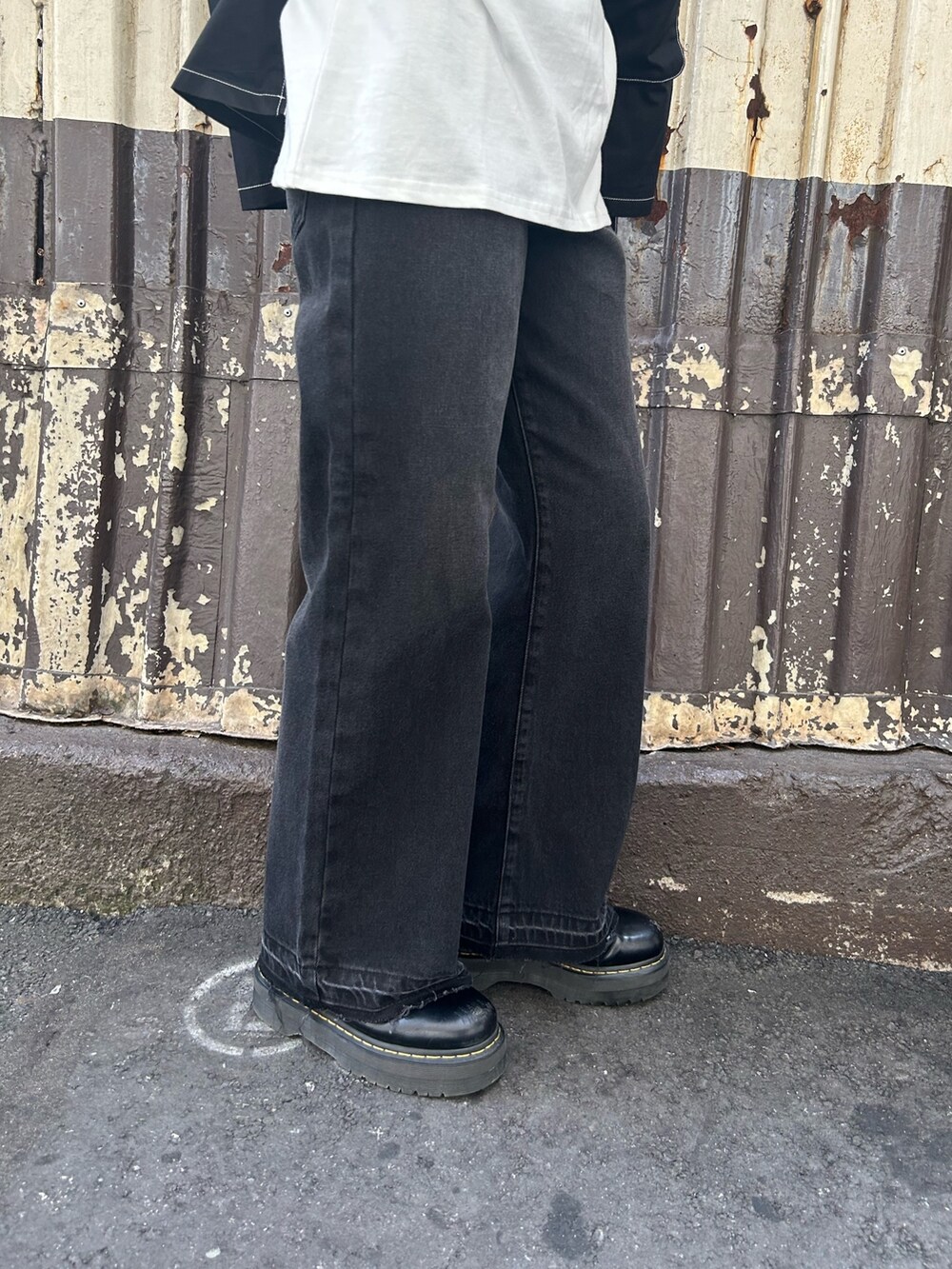 ブラック系のブーツ、ブラック系のデニムパンツ、ホワイト系のTシャツ/カットソーを着用したレディースの夏コーディネートの8枚目の写真