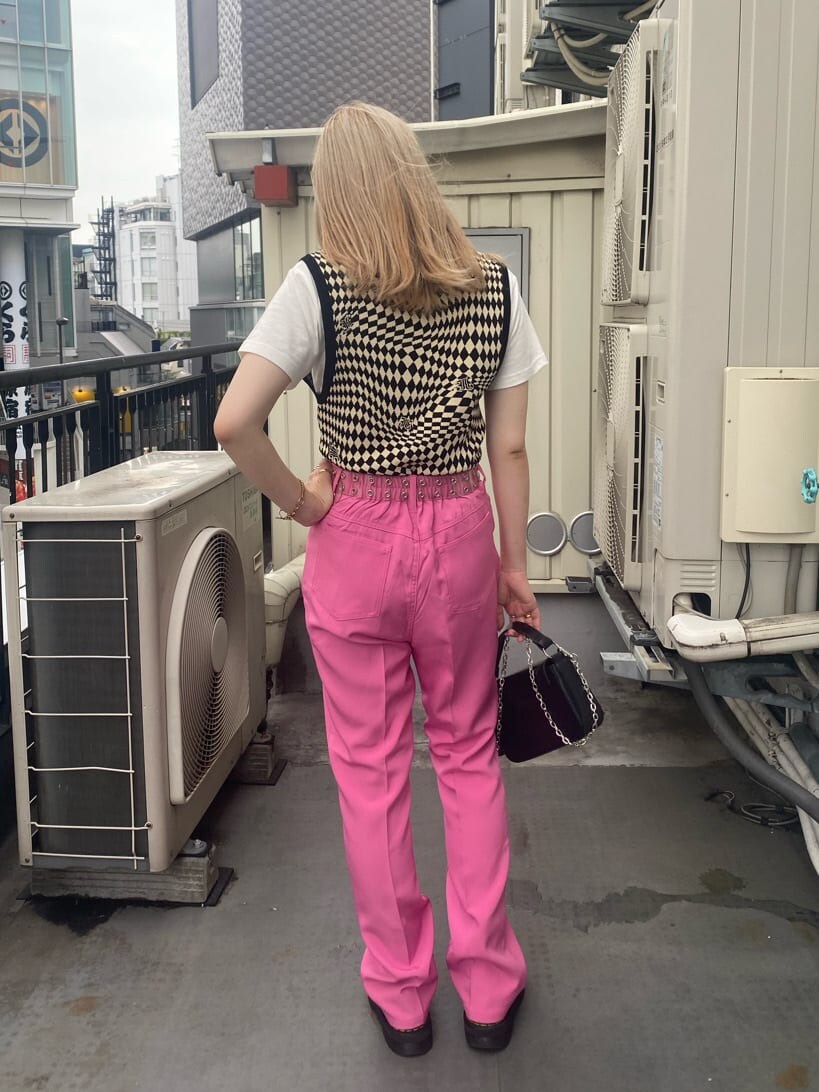 ブラック系のニット/セーター、ホワイト系のTシャツ/カットソー、ピンク系のスラックスを着用したレディースの夏コーディネートの4枚目の写真