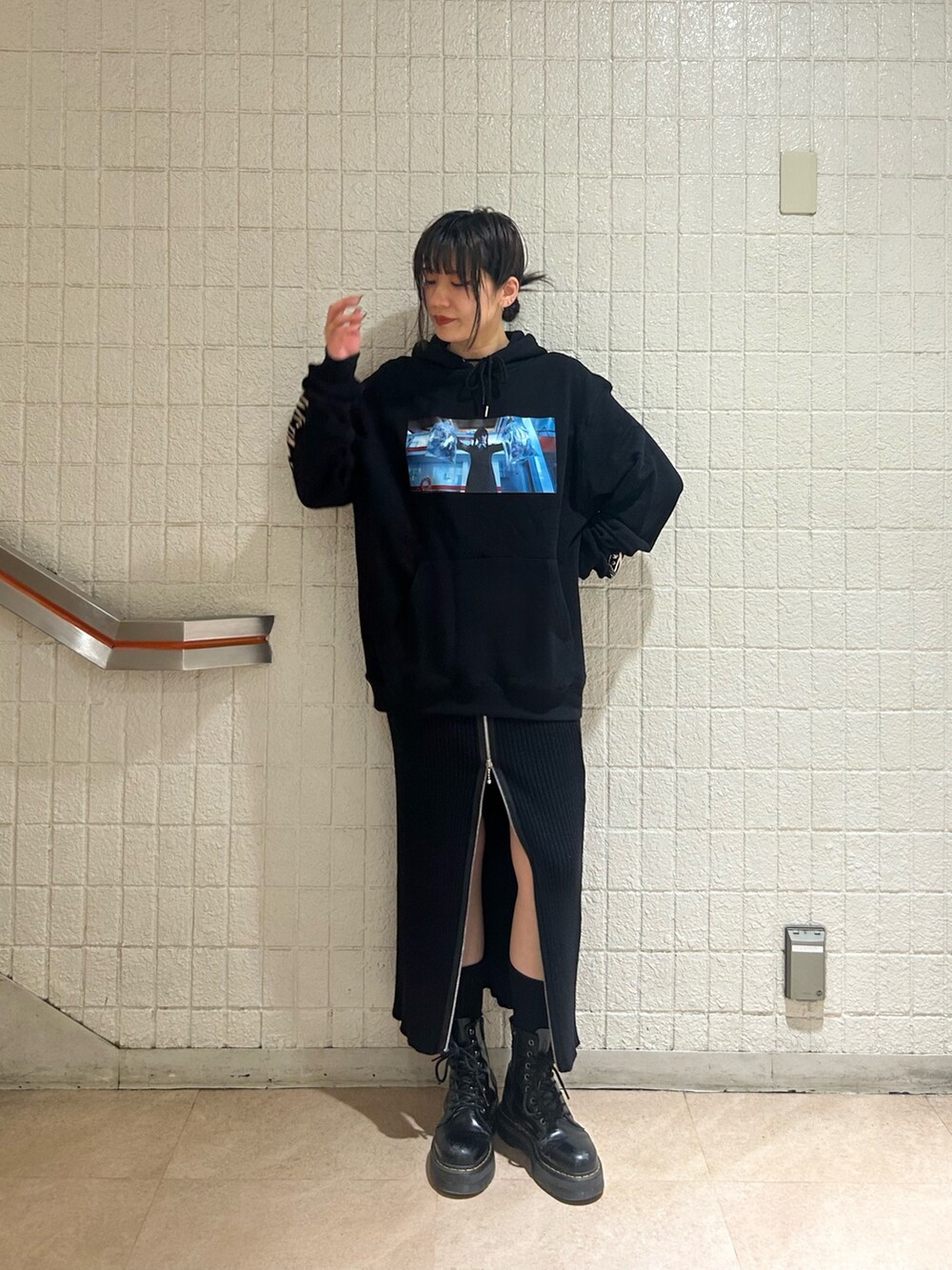 ブラック系のブーツ、ブラック系のスカート、ブラック系のパーカーを着用したレディースの秋コーディネートの2枚目の写真