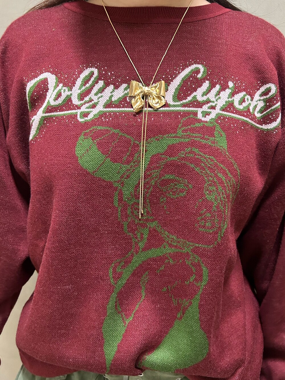 ブラック系のブーツ、レッド系のニット/セーター、グリーン系のスカートを着用したレディースの秋コーディネートの7枚目の写真