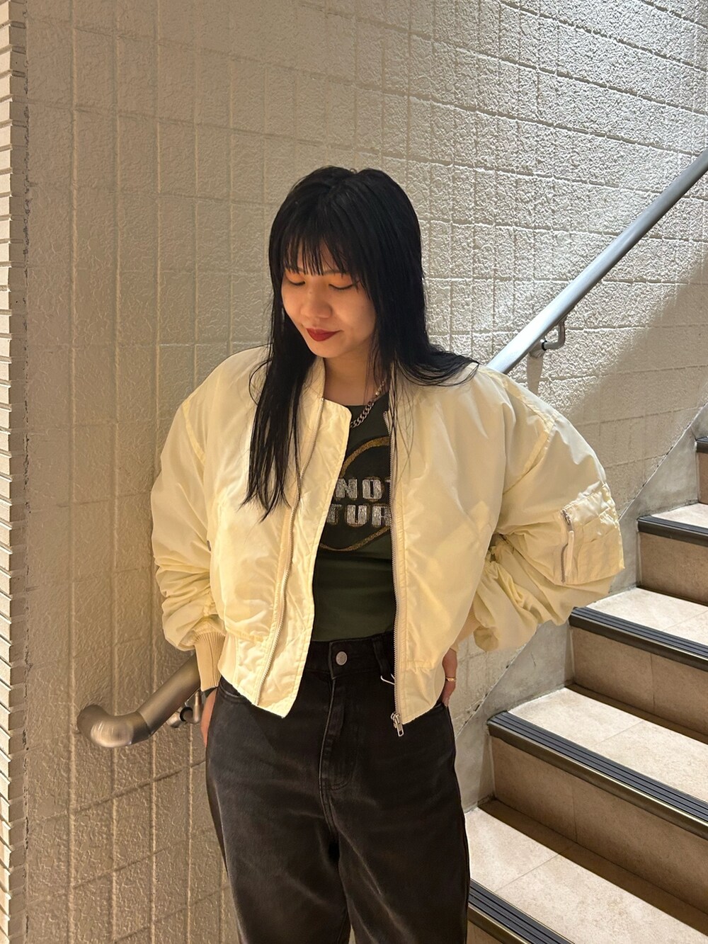 ベージュ系のブーツ、ブラック系のデニムパンツ、ホワイト系のMA-1を着用したレディースの秋コーディネートの5枚目の写真