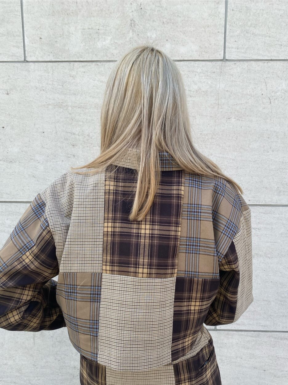 ブラック系のハンドバッグ、ブラック系のブーツ、ホワイト系のベストを着用したレディースの秋コーディネートの6枚目の写真