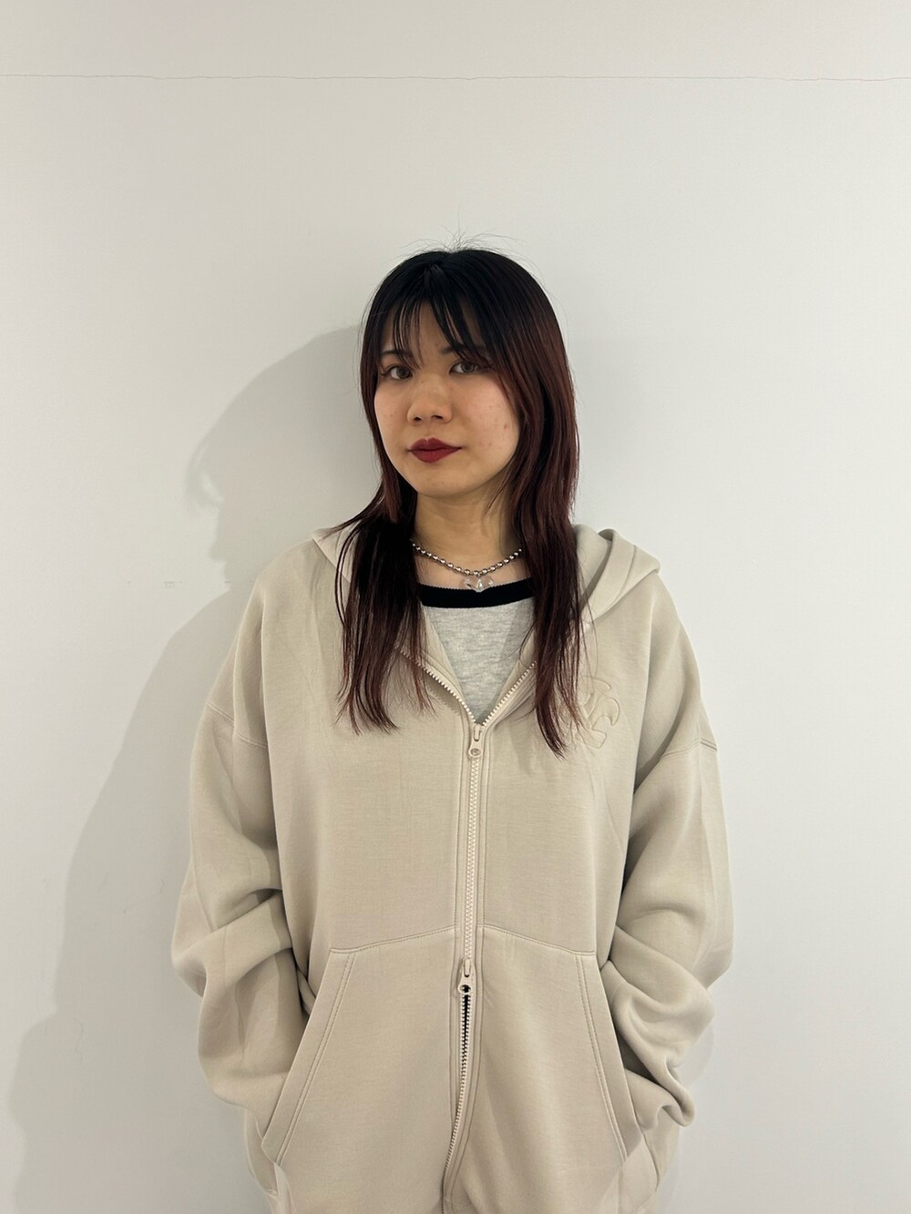 ブラック系のデニムパンツ、ホワイト系のパーカー、ホワイト系のニット/セーターを着用したレディースの春コーディネートの3枚目の写真