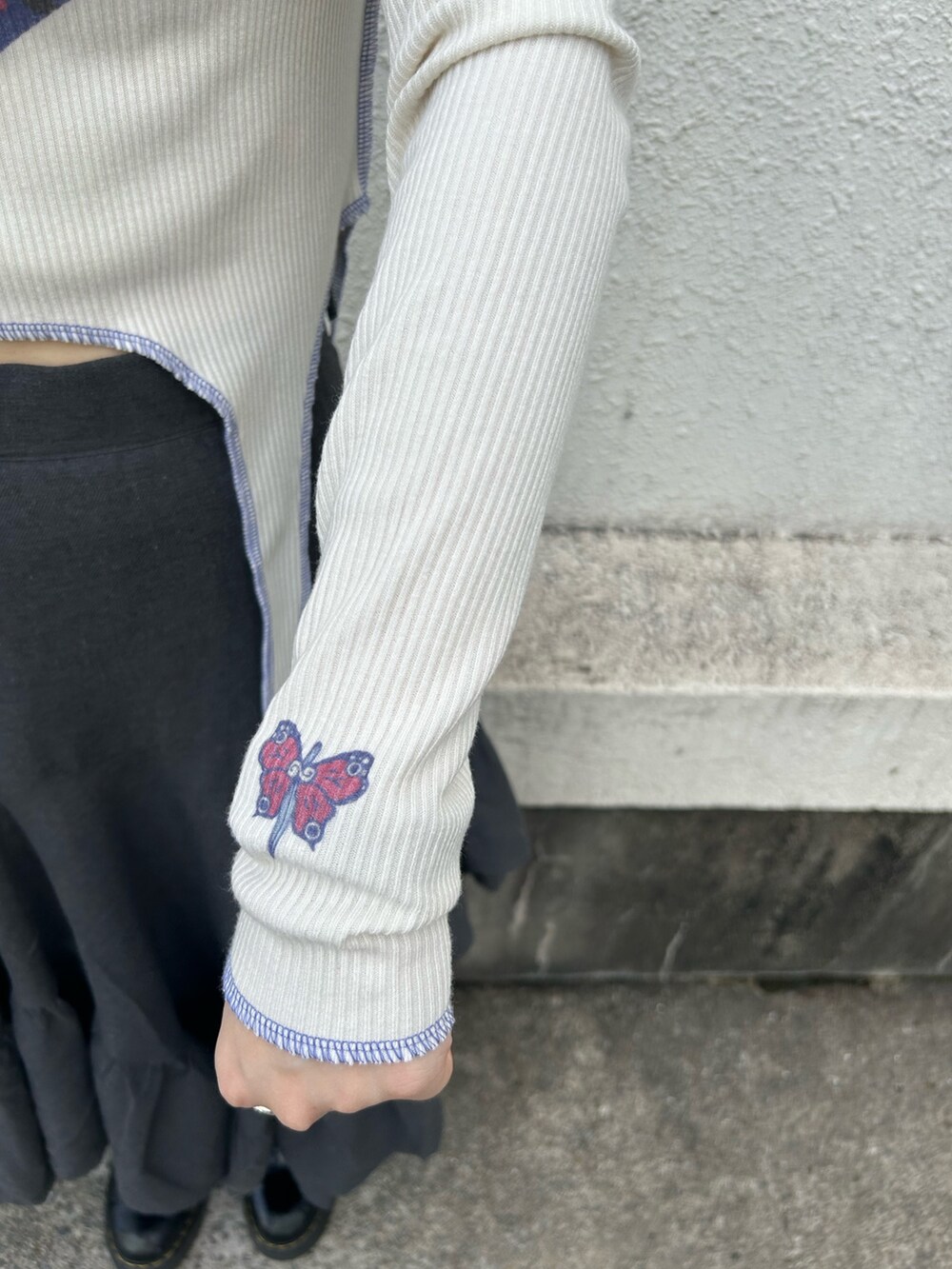 ブラック系のブーツ、ホワイト系のTシャツ/カットソー、グレー系のスカートを着用したレディースの秋コーディネートの7枚目の写真