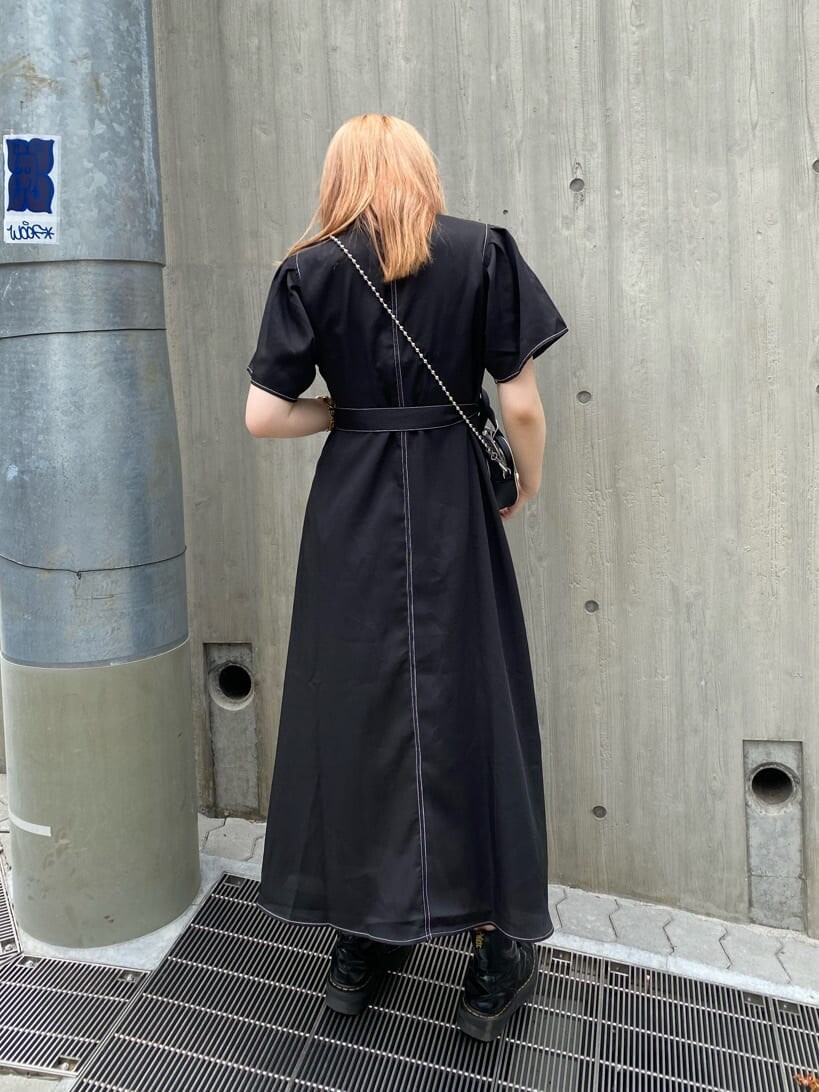 ブラック系のブーツ、ブラック系のワンピース、ブラック系のボストンバッグを着用したレディースの夏コーディネートの3枚目の写真