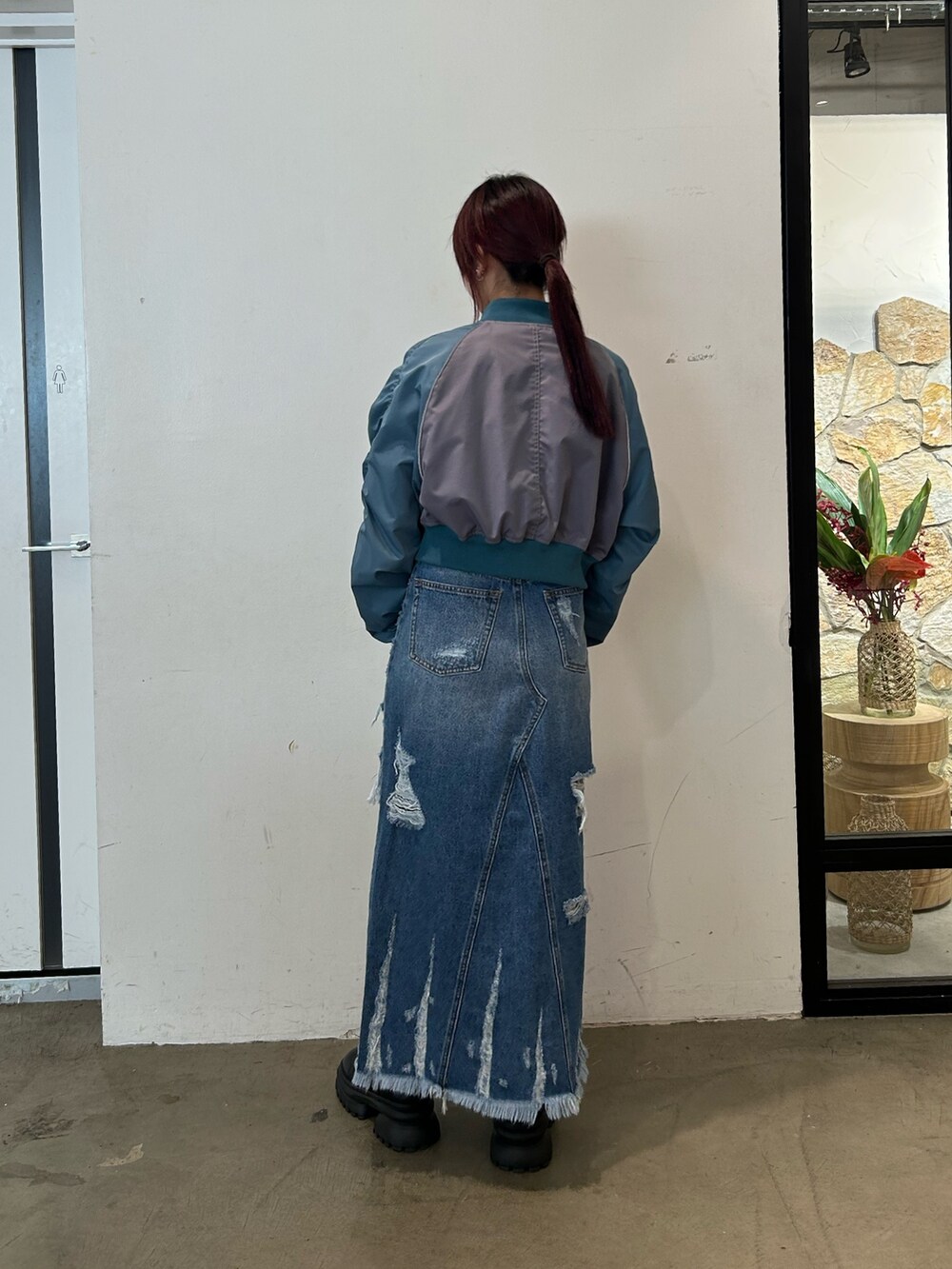 ブラック系のブーツ、グレー系のブルゾン、ブルー系のデニムスカートを着用したレディースの春コーディネートの3枚目の写真