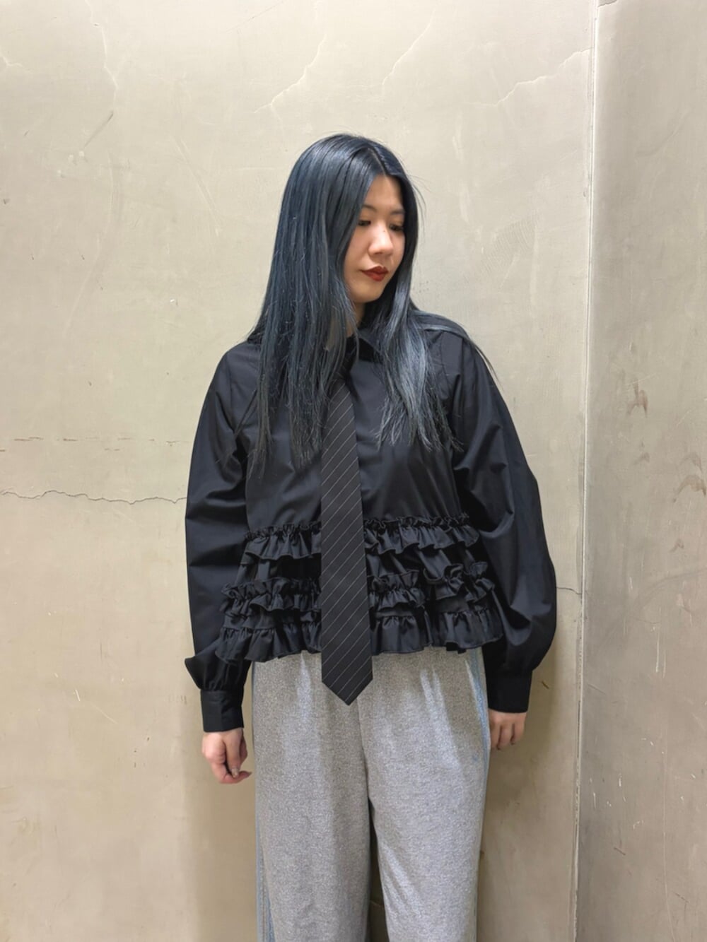 ブラック系のシャツ/ブラウス、ブラック系のパンプス、グレー系のその他パンツを着用したレディースの春コーディネートの4枚目の写真