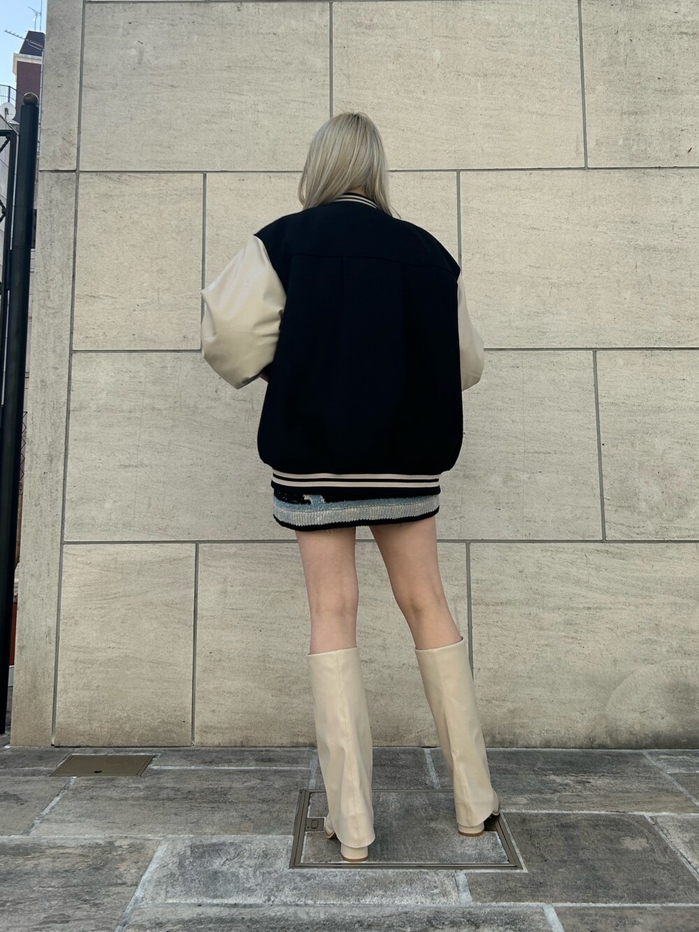 ブラック系のデニムパンツ、ホワイト系のブーツ、ブラック系のニット/セーターを着用したレディースの冬コーディネートの3枚目の写真