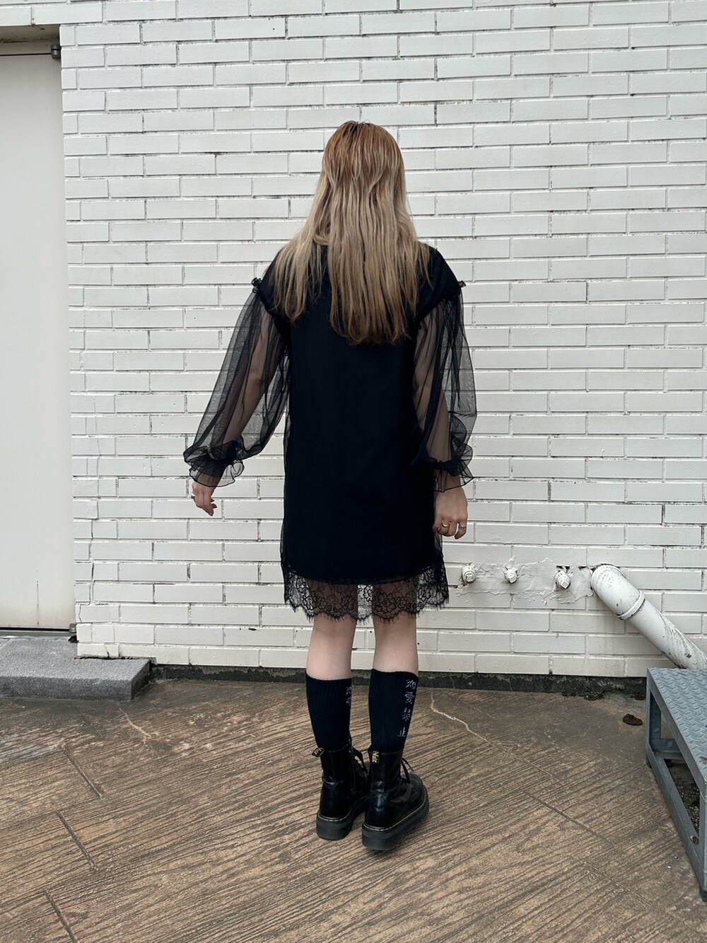 ブラック系のブーツ、ブラック系のワンピースを着用したレディースの夏コーディネートの3枚目の写真