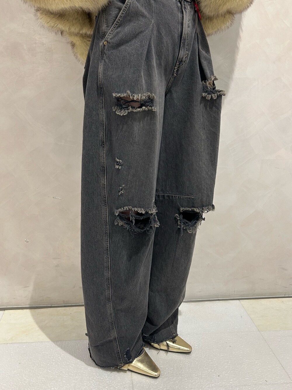 ブラック系のデニムパンツ、ゴールド系のパンプス、ブラック系のTシャツ/カットソーを着用したレディースの秋コーディネートの9枚目の写真