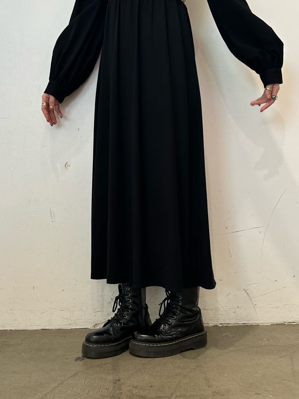 ブラック系のワンピース、ブラック系のブーツを着用したレディースの秋コーディネートの6枚目の写真