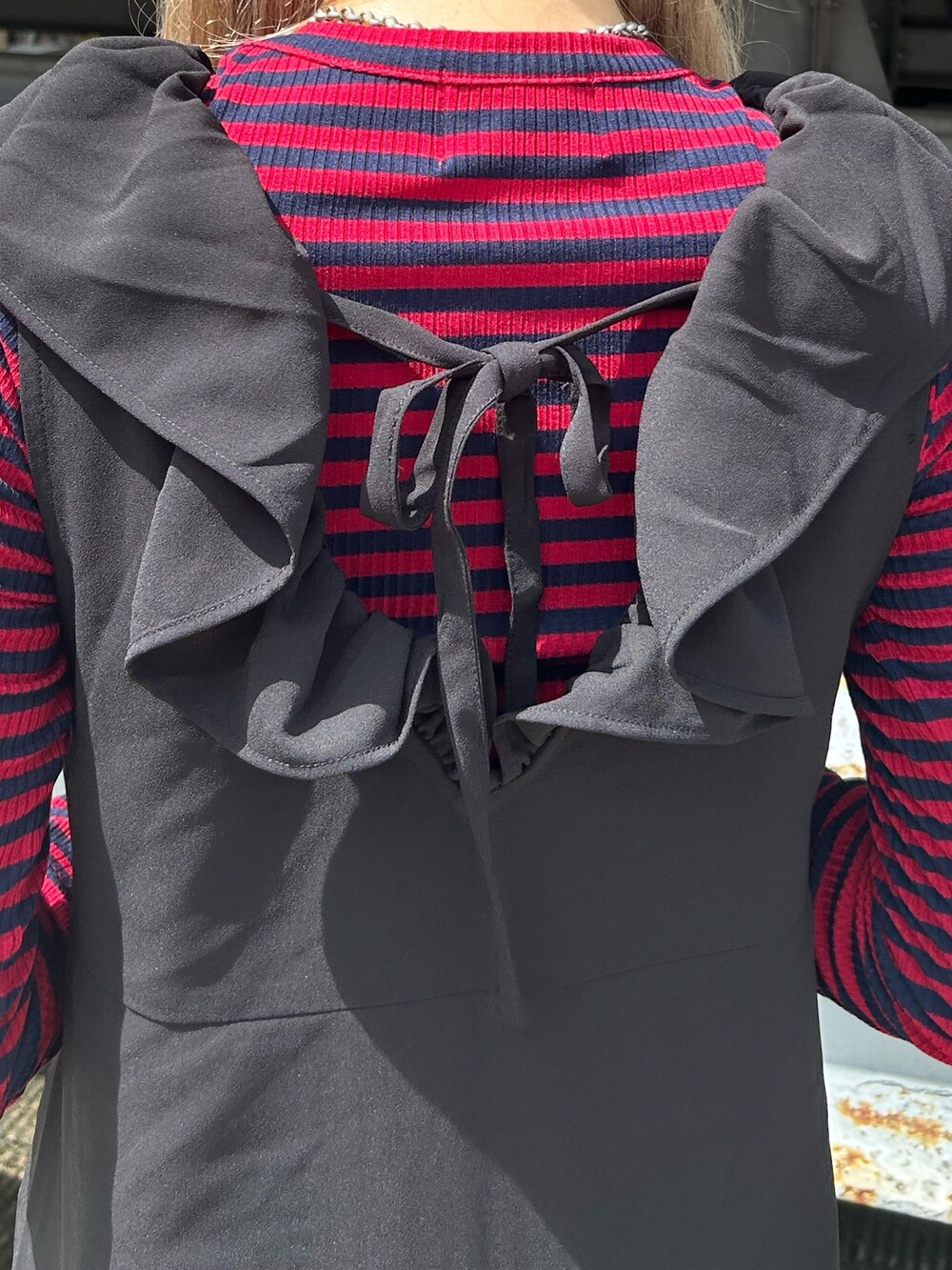 ブラック系のブーツ、ブラック系のワンピース、レッド系のTシャツ/カットソーを着用したレディースの夏コーディネートの5枚目の写真