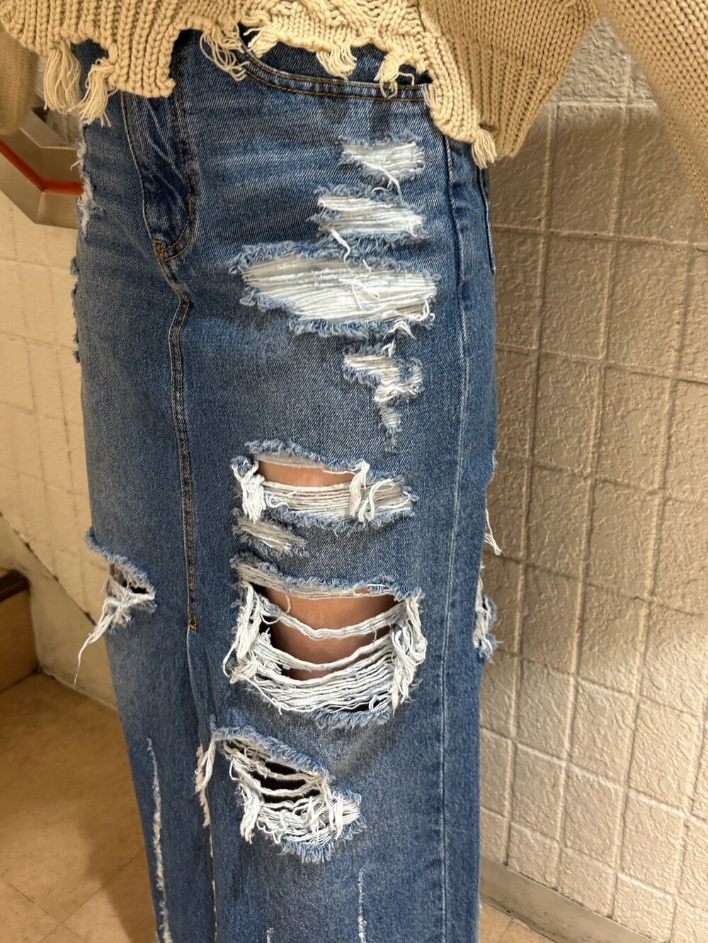 ブラック系のブーツ、ブルー系のデニムスカート、ホワイト系のニット/セーターを着用したレディースの冬コーディネートの9枚目の写真