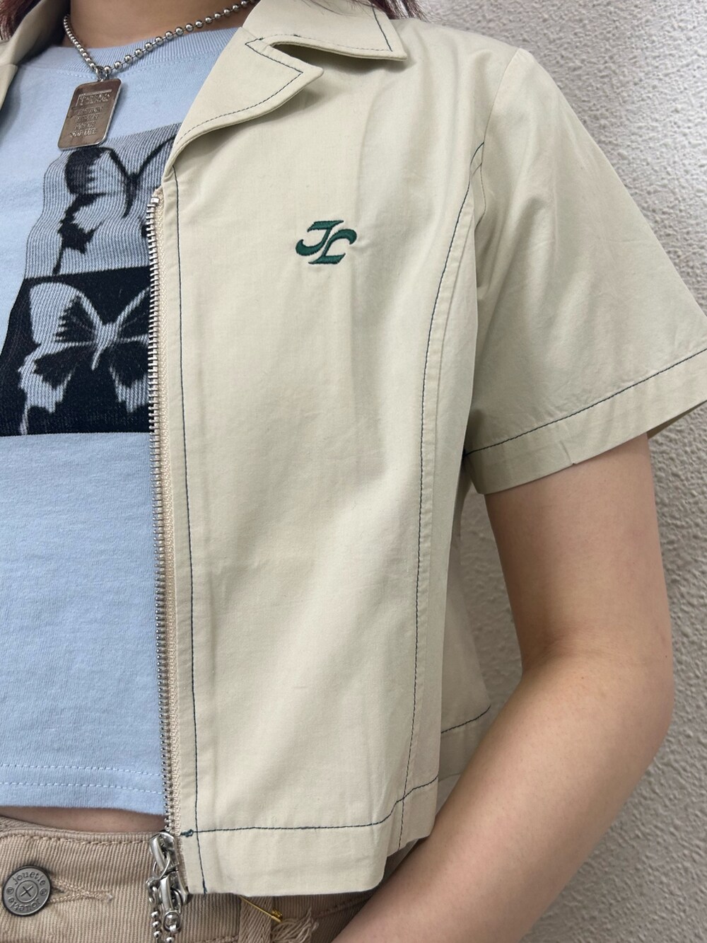 ベージュ系のスカート、ブラック系のブーツ、ブルー系のTシャツ/カットソーを着用したレディースの夏コーディネートの4枚目の写真