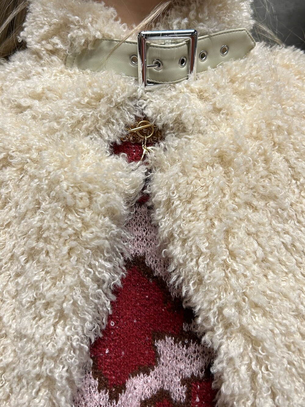 レッド系のニット/セーター、ブルー系のデニムパンツ、ホワイト系のその他アウターを着用したレディースの冬コーディネートの5枚目の写真